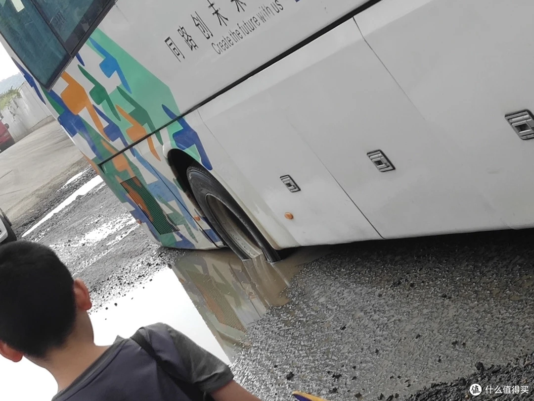 机场大巴后轮完全陷入坑里动弹不得